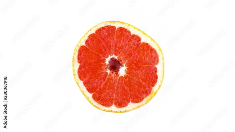 Cross section of a pink grapefruit. Rotating on the turntable. Isolated on the white background. Close-up. Macro. Cross section of a pink grapefruit. Rotating on the turntable. Isolated on the white background. Close-up. Macro.
