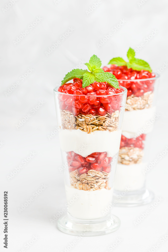 Pomegranate parfait - sweet organic layered dessert with granola flakes, yogurt and red ripe fruit seeds. Pomegranate parfait - sweet organic layered dessert with granola flakes, yogurt and red ripe fruit seeds.