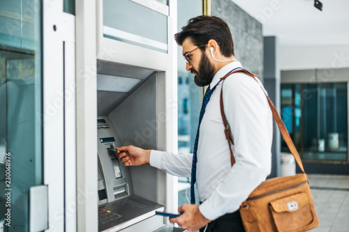 Businessman using card at an ATM