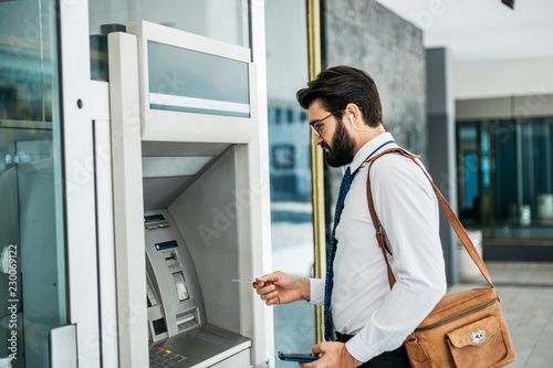 Businessman using card at an ATM