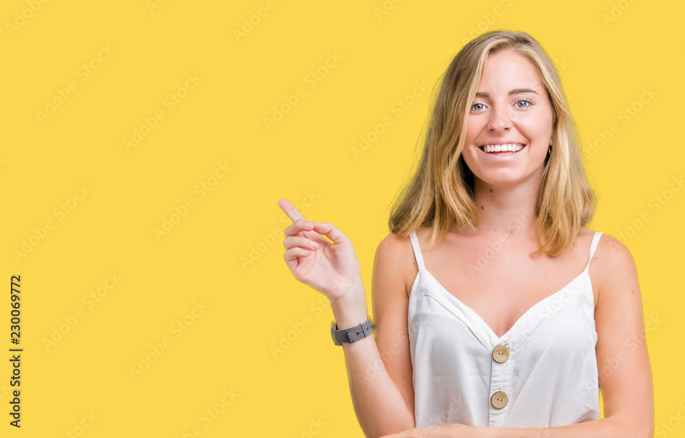 Beautiful young woman over isolated background with a big smile on face, pointing with hand and finger to the side looking at the camera. Beautiful young woman over isolated background with a big smile on face, pointing with hand and finger to the side looking at the camera.