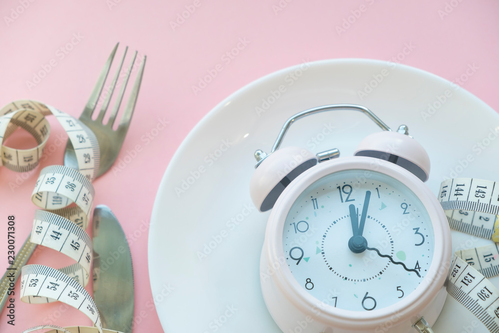 Time to lose weight , eating control or time to diet concept , alarm clock with healthy tool concept decoration on pink background