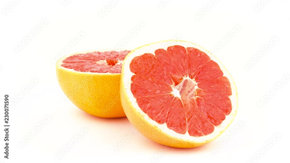 Two halves of a pink grapefruit. Rotating on the turntable. Isolated on the white background. Close-up. Macro. Two halves of a pink grapefruit. Rotating on the turntable. Isolated on the white background. Close-up. Macro.