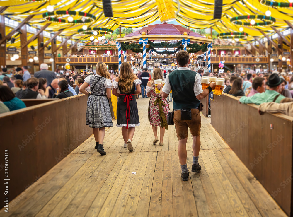 Obraz premium Oktoberfest, Monachium, Niemcy. Kelner trzymając piwa, tło wnętrze namiotu