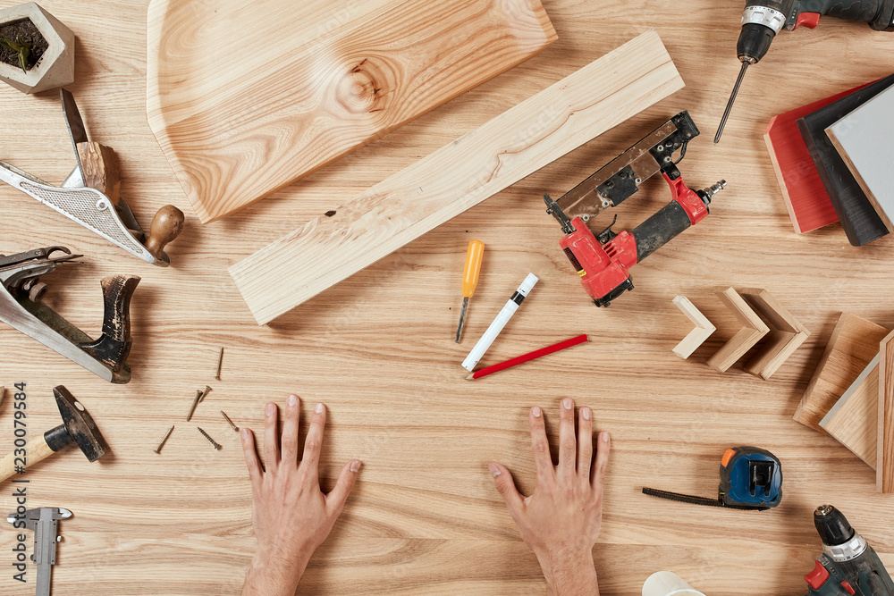 Collection of carpentry tools with male hand making notes in blank