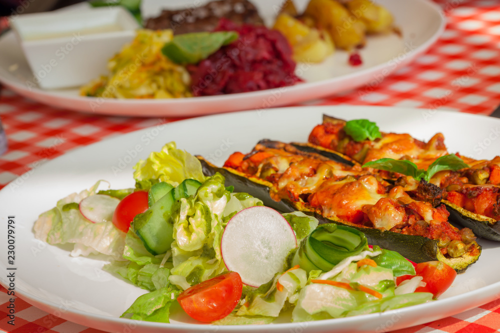 Healthy dinner plate - Zucchini stuffed vegetables and salad - letuce with cherry tomatoes, radish and cucumber Healthy dinner plate - Zucchini stuffed vegetables and salad - letuce with cherry tomatoes, radish and cucumber