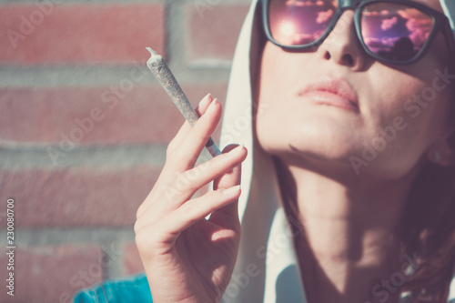 Young woman with weed joint. Marijuana and cannabis legalisation concept. photo