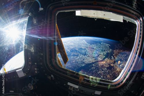 Fototapeta Naklejka Na Ścianę i Meble -  Collage image with huge NY city at night with city lights from the outer space from the ISS window. Elements of this image furnished by NASA.