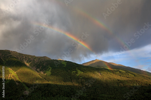 Double Rainbow in the sky above Kanas Nature Reserve. Xinjiang Province, China. Clouds, alpine high altitude forest and fresh air. Altai Mountains near the border of, Kazakhstan, Russia and Mongolia.