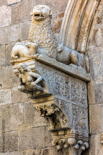 The portal of the Cathedral of Saint Mark in Korcula, Croatia, built by Bonino da Milano in 1412 contains typical Romanesque motifs such as a lion tearing its prey and a crouching figure of Eve photo