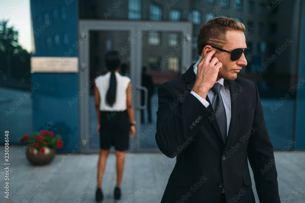 Serious bodyguard in suit and sunglasses, guarding Serious bodyguard in suit and sunglasses, guarding