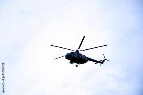 a large military helicopter hovers in the sky. A camouflaged helicopter flies at high speed.