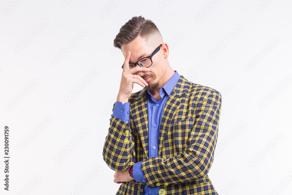 Emotions and people concept - handsome young man in jacket with beard and whisker in glasses thinking about something over white background Emotions and people concept - handsome young man in jacket with beard and whisker in glasses thinking about something over white background
