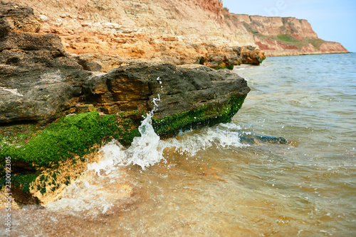 beautiful sea landscape, closeup of stone on the beach, sea coast with high hills, wild nature photo