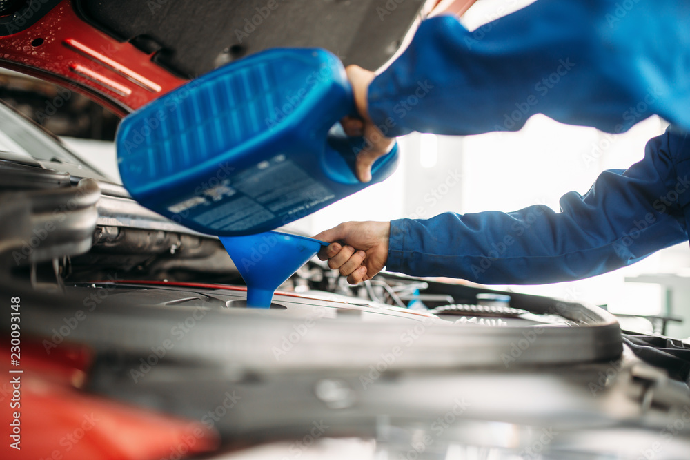 Technician change oil in the car engine