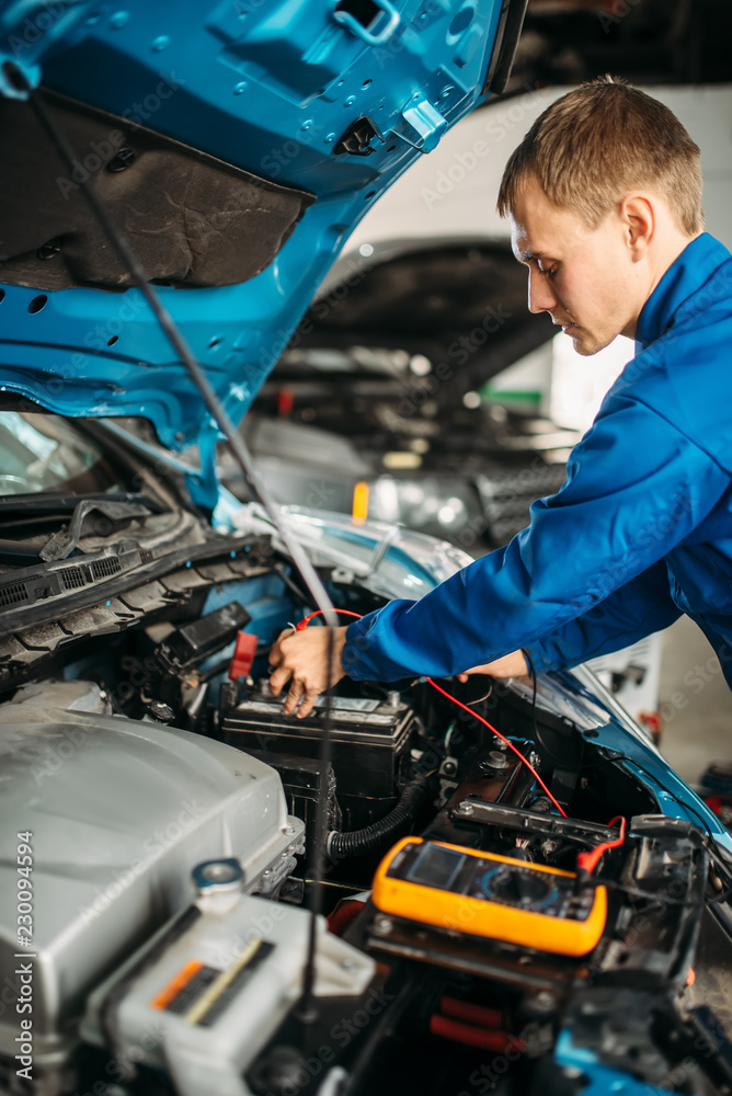 Car electrician checks the battery level Car electrician checks the battery level