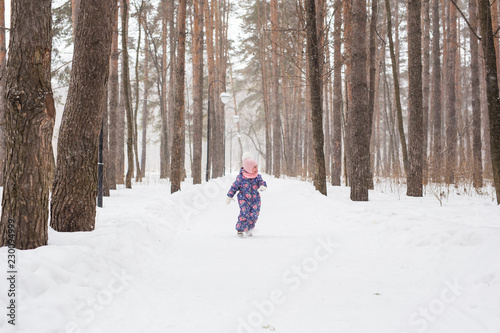 Children, winter and nature concept - Close up of adorable kid playing with snow in the park