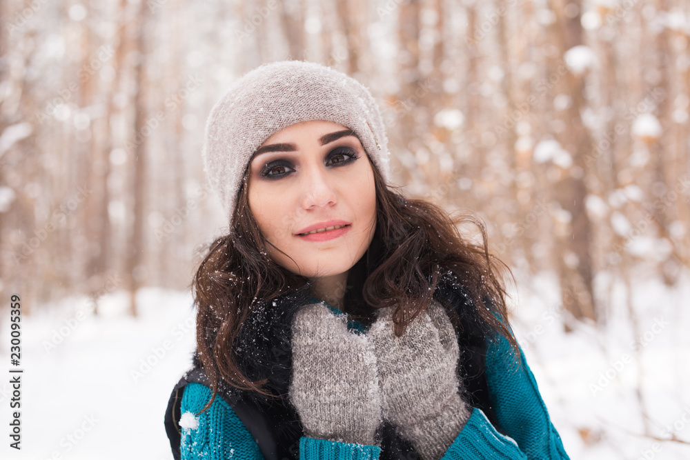 Portrait of young pretty woman walking in the winter snowy park at sunny day Portrait of young pretty woman walking in the winter snowy park at sunny day