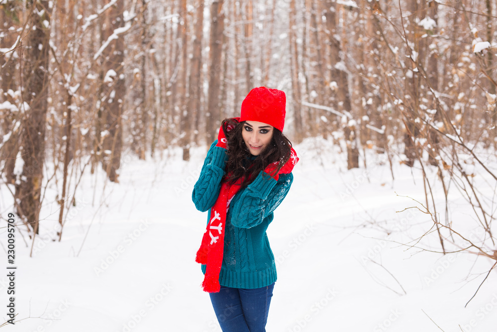 Winter, season and people concept - Young pretty woman walking in snowy park