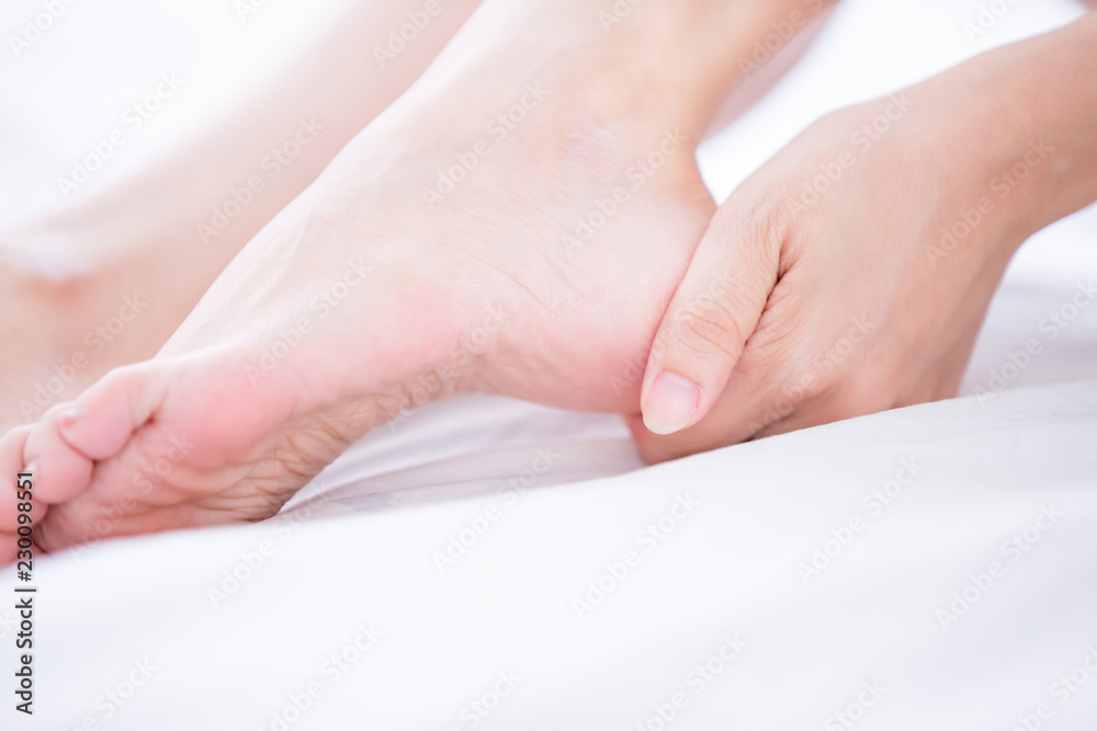 Fototapeta premium Woman applying cream onto foot
