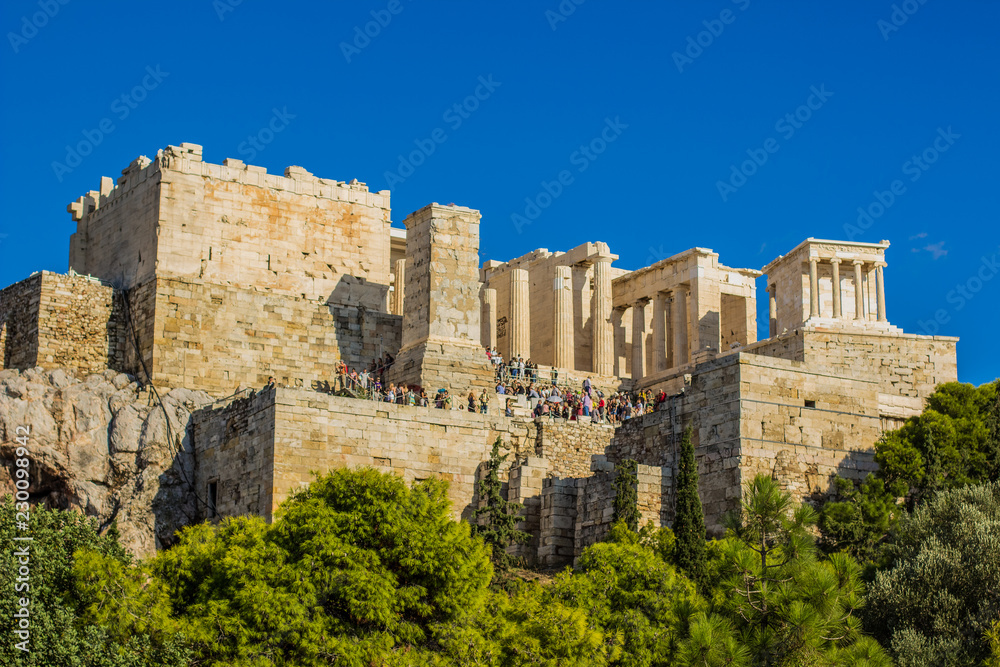 touristic place ancient marble temple ruins with a lot of tourists, colorful picture with yellow blue and green vivid colors