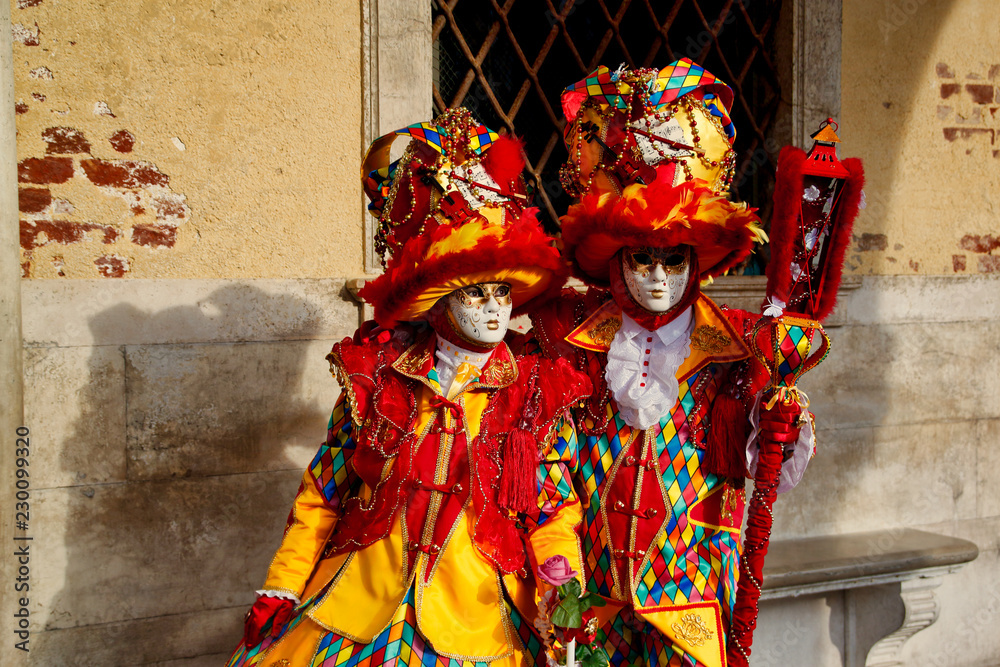 Colorful carnival red-yellow mask and costume at the traditional festival in Venice, Italy