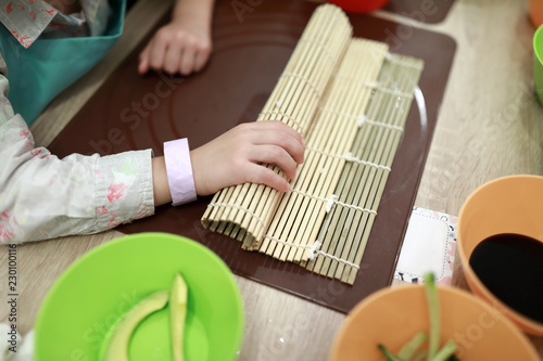Child preparing sushi rolls