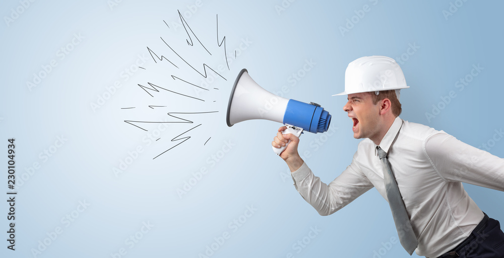 Fototapeta premium Young architect constructor yelling with megaphone and copyspace 