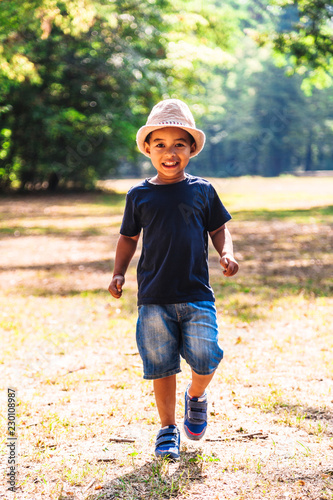 Fotografie Close up portrait of little boy running outdoors in park