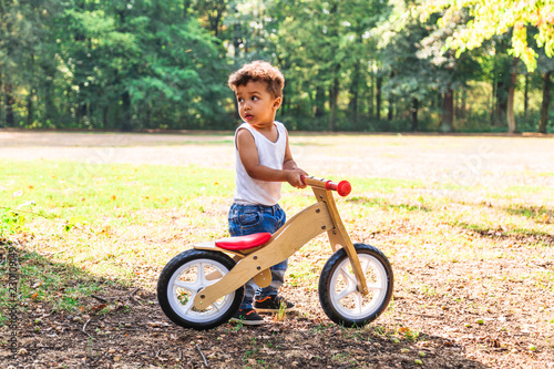 Afro-american or latin little boy ride bicycle outdoor
