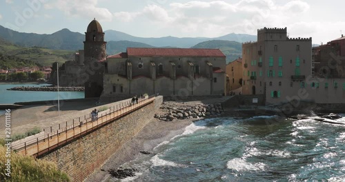 Collioure, France. People Tourists Walking In Coast Near Church Of Our Lady Of The Angels Across The Bay In Sunny Spring Day photo