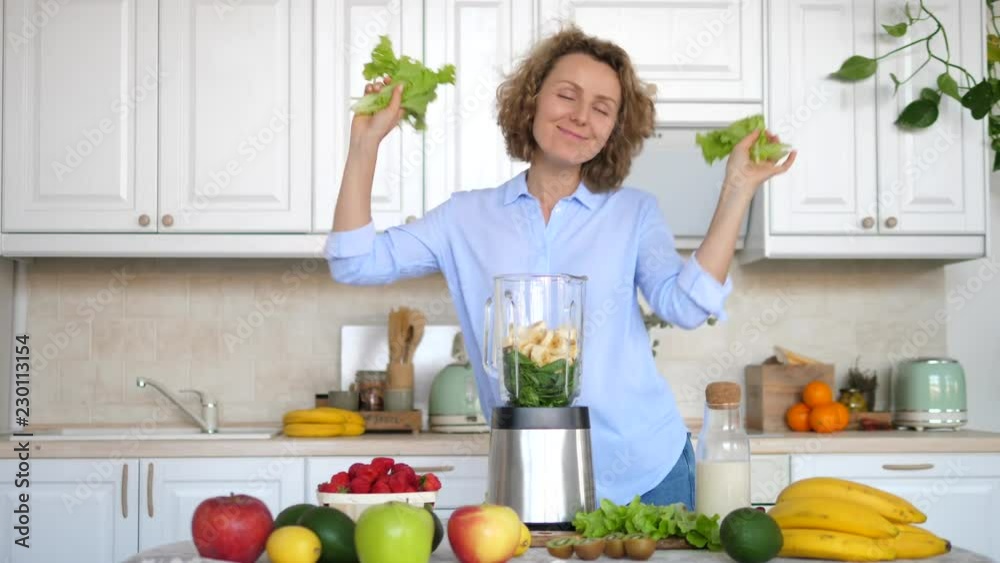 Young Woman Dancing And Preparing Healthy Smoothie On Kitchen Young Woman Dancing And Preparing Healthy Smoothie On Kitchen