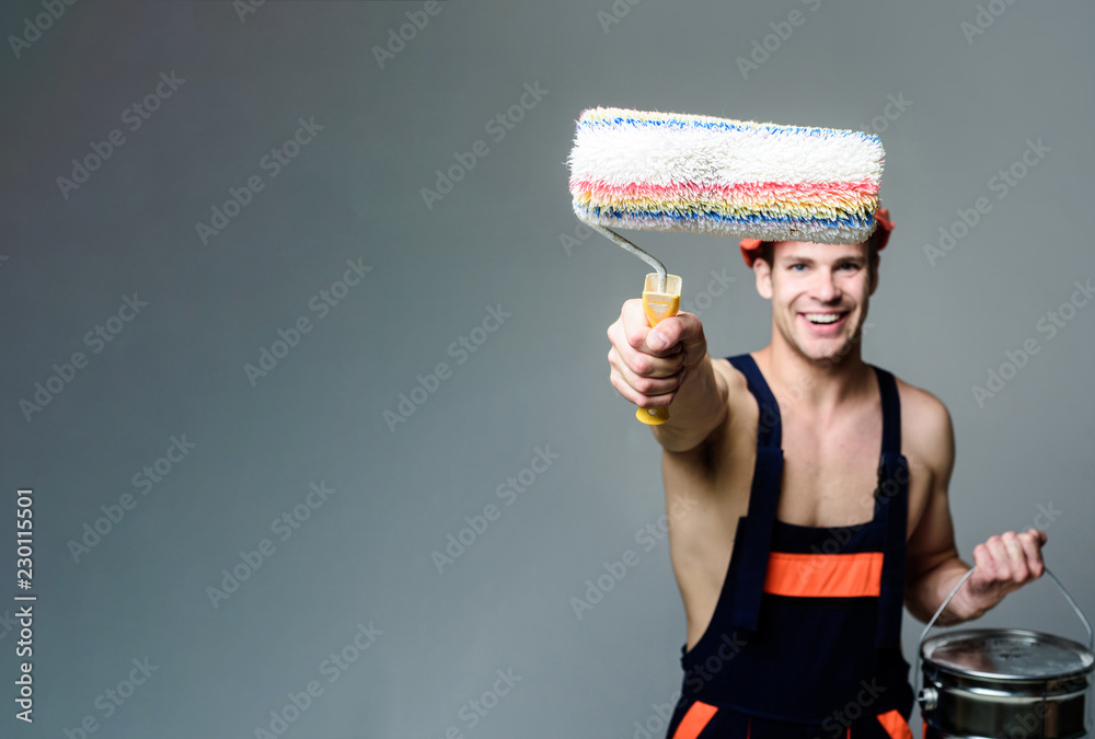 Painter man painting wall with paint roller&bucket. Male decorator in uniform with paint roller&bucket. Worker holds interior painting roller. Decorator painting wall with roller. Renovation concept. Painter man painting wall with paint roller&bucket. Male decorator in uniform with paint roller&bucket. Worker holds interior painting roller. Decorator painting wall with roller. Renovation concept.
