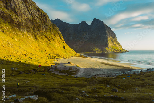 Beautiful view of Lofoten Kvalvika Beach an amazing sunny summer day. Dry grass and heather bushes. Hikers tent, Norway 2018