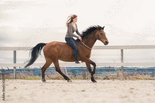 Frau galoppiert Pferd mit Halsring