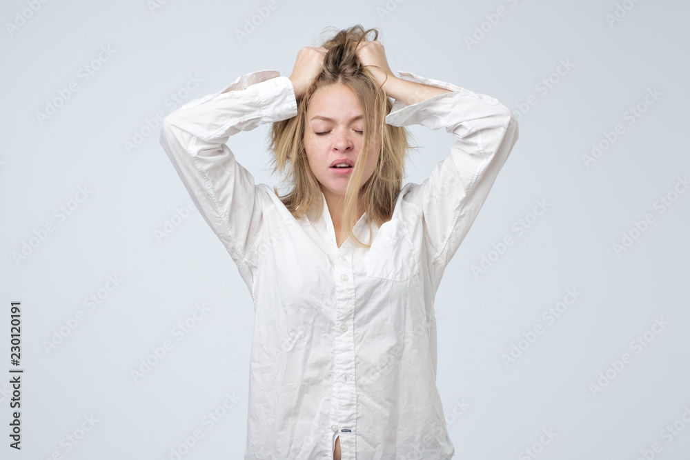 Sleepy or drowsy young girl wearing white shirt of her boyfriend, isolated on white. Unkempt tired girl Sleepy or drowsy young girl wearing white shirt of her boyfriend, isolated on white. Unkempt tired girl