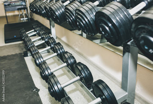 Heavy dumbbells lying in the raw in the gym. Fitness sport motivation. Happy healthy lifestyle living. Exercises with bars weights.