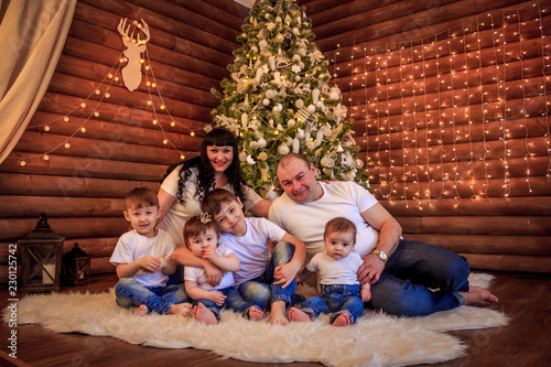 A large happy family gathered at home under the Christmas tree. Same outfits for the whole family. Festive mood. New Year's and Christmas. Big family. © alenka2194