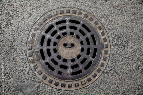 Manhole cover in the road of asphalt