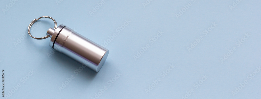 Metal container for pills on a blue background, close-up Metal container for pills on a blue background, close-up