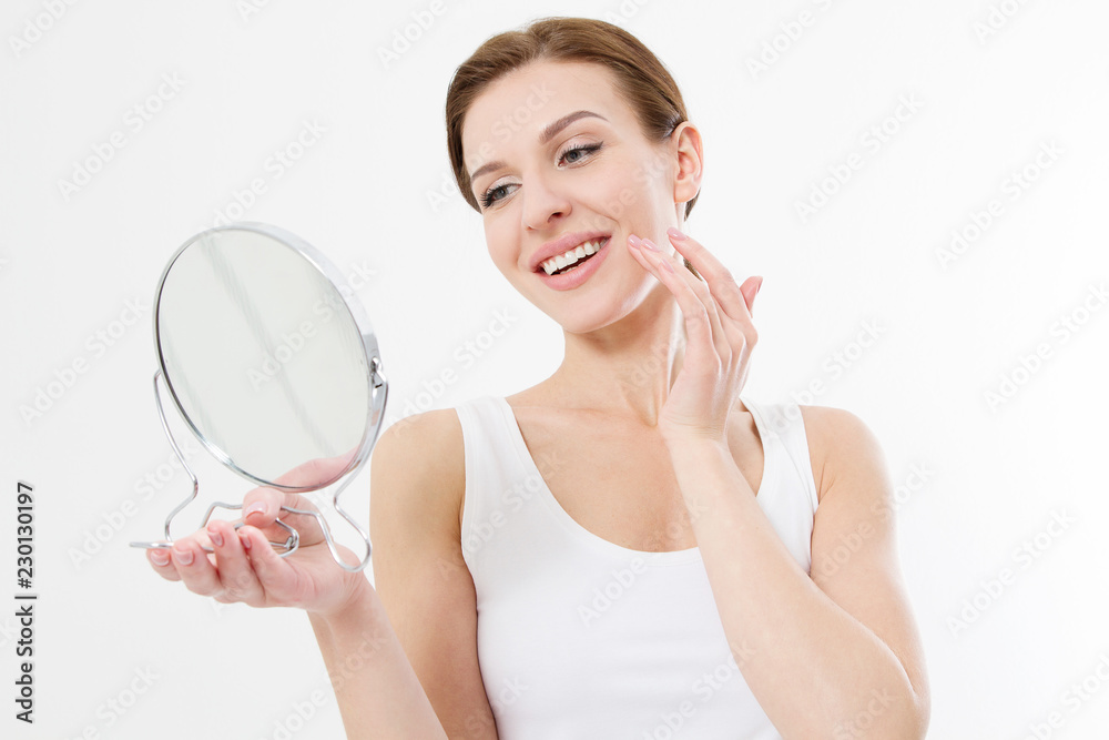 Smiling young woman with white teeth looking in mirror isolated on white background. Skin care and anti aging concept. Beauty and body health. Copy space Smiling young woman with white teeth looking in mirror isolated on white background. Skin care and anti aging concept. Beauty and body health. Copy space