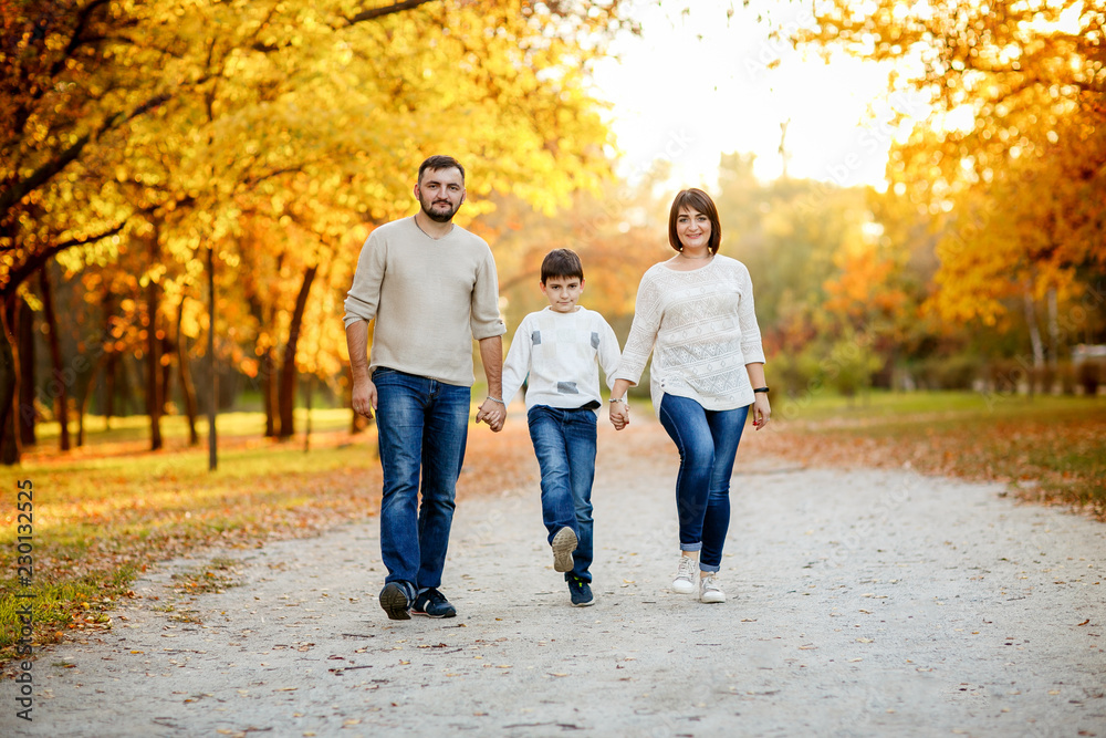 Happy family with teenage son outing in autumn park. Educational process, socialization of children. Happy family with teenage son outing in autumn park. Educational process, socialization of children.
