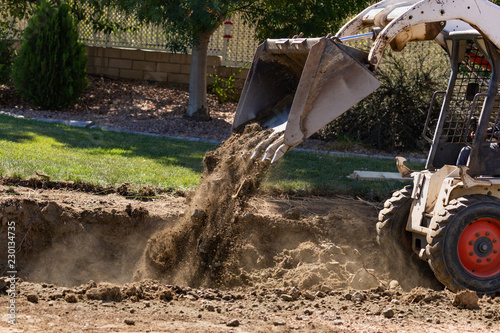 Фотография Small Bulldozer Digging In Yard For Pool Installation