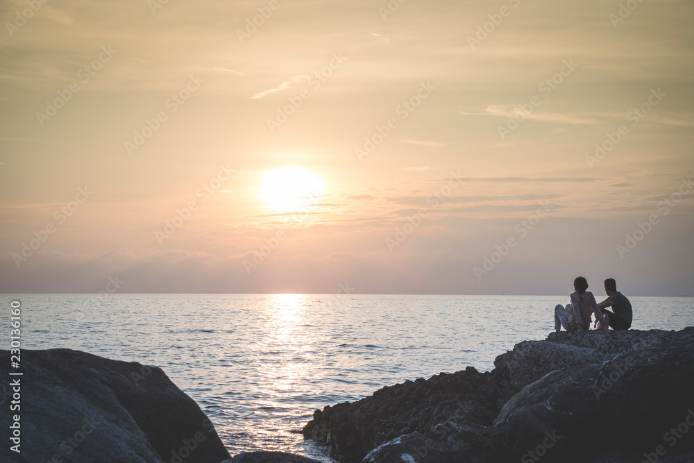 Couple admires the sunset on the sea