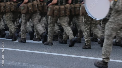 Men in camo clothig march at street photo