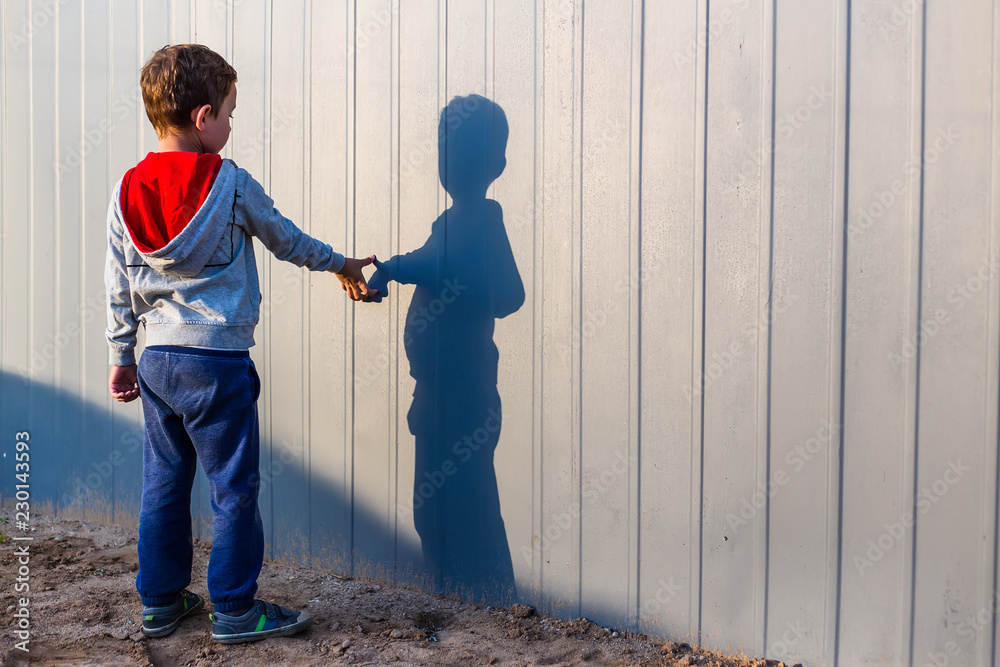 boy and his shadow. Lonely little child playing with his shadow outside.  imaginary friend. the concept of autism and loneliness. Copy space for your  text Stock Photo | Adobe Stock