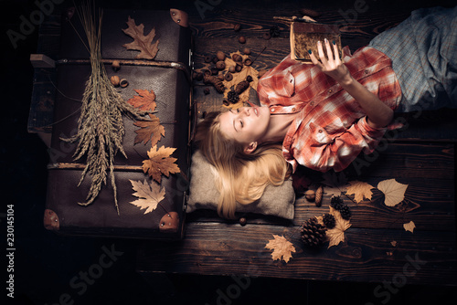 Beautiful sensual blonde read book. Autumn concept. Girl in autumn in seasonal clothes whith golden leaf. Beautiful girl with background board for Copyspace.