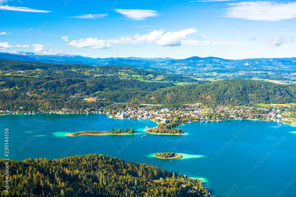 Worthersee is the largest lake of province Carinthia in Austria. The lake attracts visitors to swim and to ice skate when freezes over in winter. Sandbanks appear light green in the blue lake water.