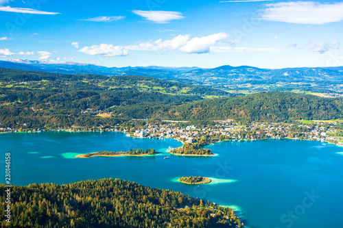 Worthersee is the largest lake of province Carinthia in Austria. The lake attracts visitors to swim and to ice skate when freezes over in winter. Sandbanks appear light green in the blue lake water.