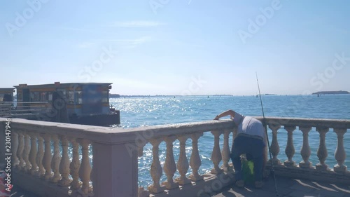 Fisherman on the promenade in Venice near Vaporetto stop photo